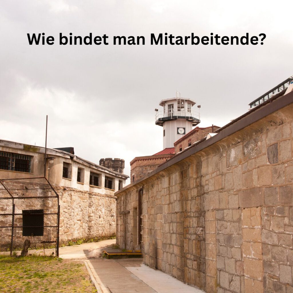 Symbolbild Mitarbeiterbindung – Frage „Wie bindet man Mitarbeitende?“ vor einer Mauer, als Denkanstoß zur modernen Mitarbeiterführung.
