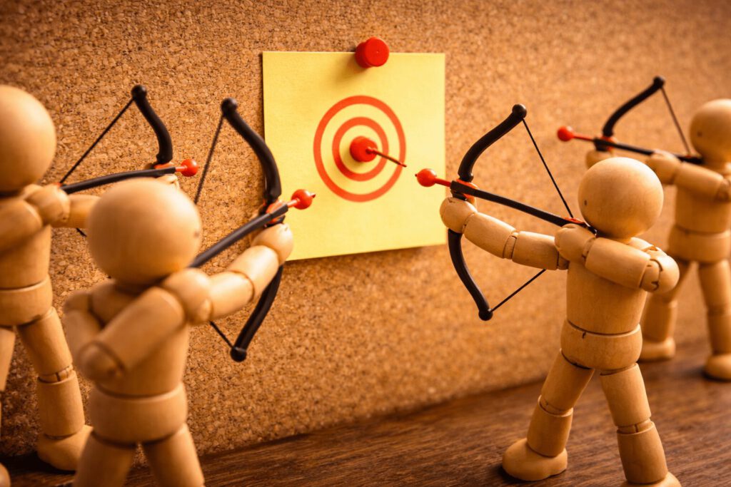 Mehrere Figuren zielen mit Pfeil und Bogen auf denselben Punkt.