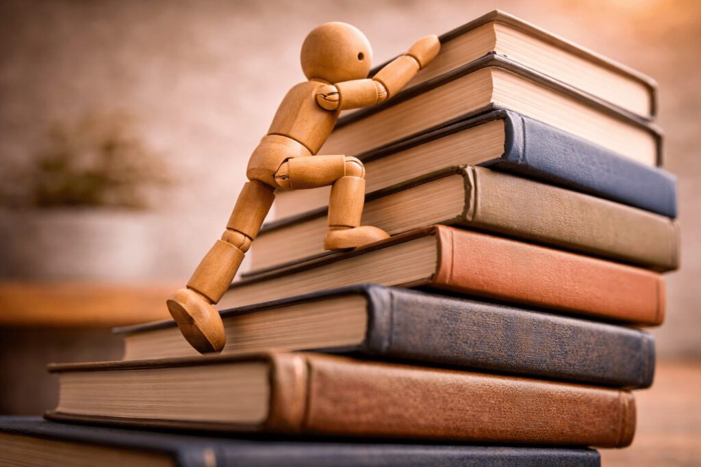 Eine Figur erklimmt dynamisch einen steilen Berg aus Hindernissen. Symbolbild für den Karriereanker Totale Herausforderung, der durch das Lösen schwieriger Probleme und den Wettbewerb motiviert wird.