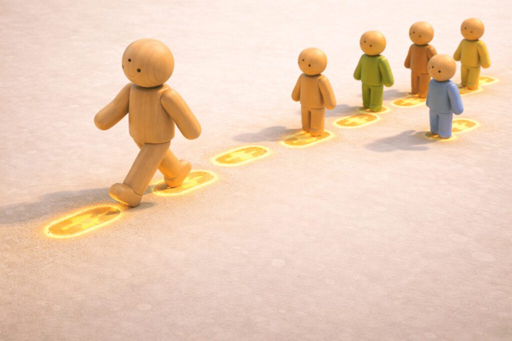 Eine große Holzfigur geht auf sandigem Boden voran und hinterlässt leuchtende, goldene Fußspuren. Eine Gruppe kleinerer Figuren folgt und tritt genau in diese Spuren. Symbolbild für die Vorbildfunktion von Führungskräften (Walk the Talk).